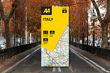 AA Road Map Italy against a background image of a road lined with trees and autumn leaves.