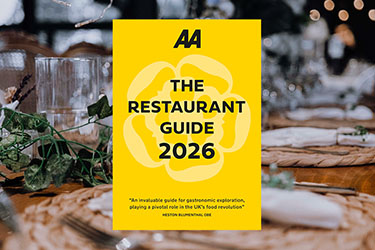 AA's Restaurant Guide 2026 against a restaurant place setting in the background.