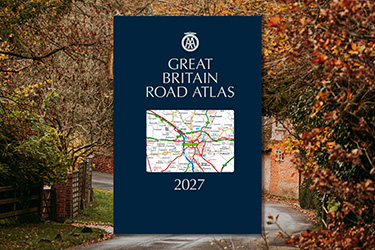 AA Great Britain Road Atlas against a background image of a country lane with autumn leaves.